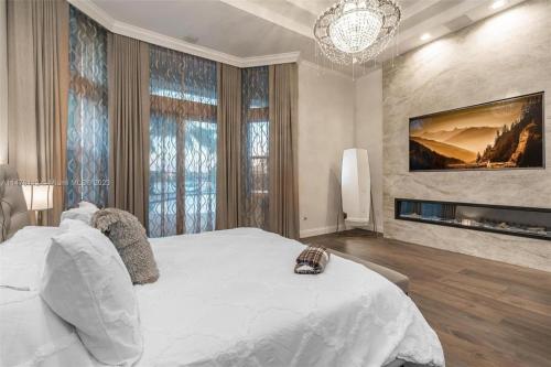 1 dormitorio con 1 cama blanca grande y chimenea en Luxury House in Pembroke Pines Newly Renovated With Pool And Security, en Pembroke Pines
