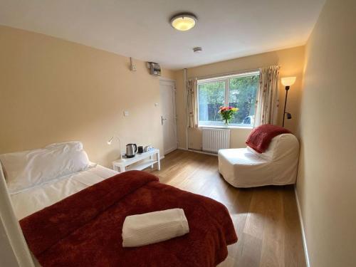 a bedroom with a bed and a chair and a window at Snowdonia Mountain Lodge in Bethesda