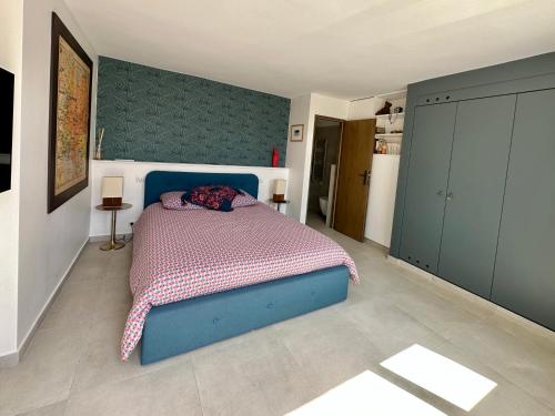 a bedroom with a blue bed in a room at Laureto BnB in Roquebrune-Cap-Martin