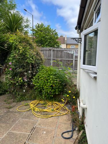 un jardín con una manguera en el lateral de una casa en Oxborne Rooms UK - 22 Seaton en Londres