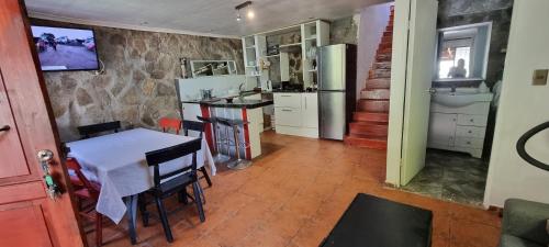 a kitchen with a table and a kitchen with a refrigerator at Casa 2h 2b con patio y quincho in Valparaíso