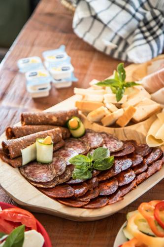 ein Holztisch mit einem Teller Crackern und Käse in der Unterkunft VB36 Vendégház in Villány