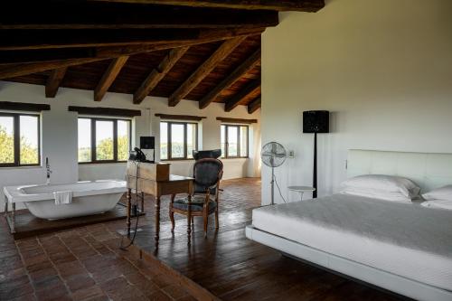 a bedroom with a bed and a tub and a desk at Castello Di Semivicoli in Casacanditella