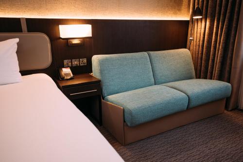 a room with a chair and a bed on a train at Crowne Plaza - Belfast by IHG in Belfast