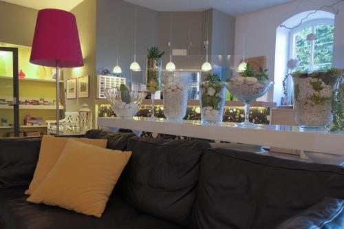 a living room with a couch and a table with vases at Hotel Liberty in Levico Terme