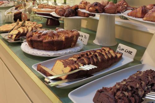 a buffet of different types of cakes and pastries at Hotel Liberty in Levico Terme