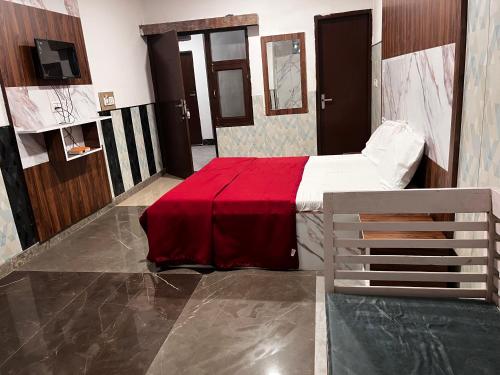a bedroom with a bed with a red blanket at Hotel Green in Kharar