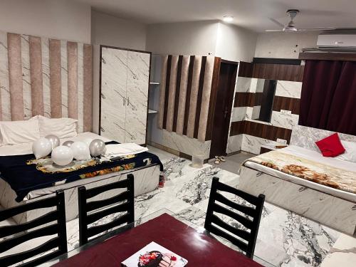 a room with two beds and a table and chairs at Hotel Green in Kharar