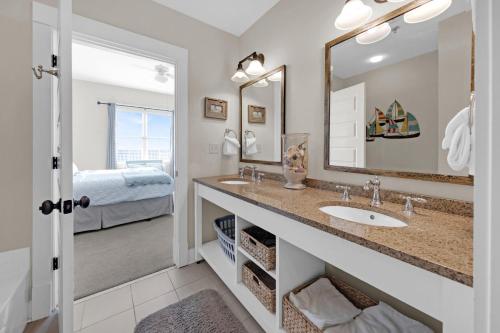 baño con lavabo, espejo y cama en Redfish Village 409 top floor stay on 30A, en Seagrove Beach