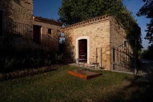 a brick building with a door in the grass at Castello Di Semivicoli in Casacanditella