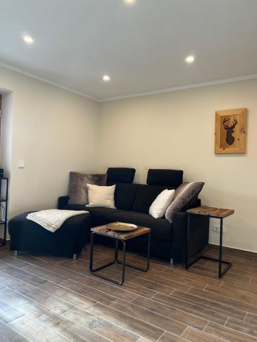 a living room with a couch and a table at BERGSUCHT-Ruhpolding, Traumlage am sonnigen Südhang, kostenlose Parkplätze, schnelles WLAN, ruhige Sackgasse, NETFLIX inklusive in Ruhpolding