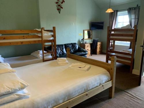a bedroom with three bunk beds and a living room at The Cromwell Arms Inn in Bovey Tracey