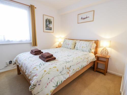 a bedroom with a bed with two towels on it at 48A South Snowdon Wharf in Porthmadog