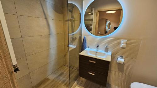 a bathroom with a sink and a mirror at Apartament Zamkowa in Opalenica