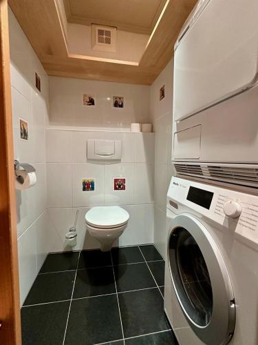 a bathroom with a washing machine and a toilet at Apartments Max & Moritz in Kirchberg in Tirol