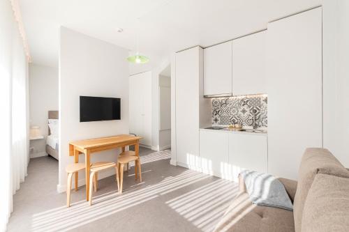 een woonkamer met een tafel en een televisie bij Soho Porto in Porto