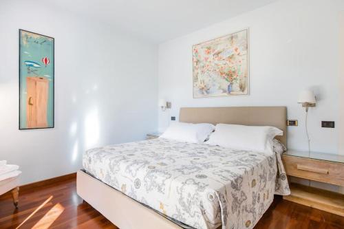 a bedroom with a bed and two paintings on the wall at Spacious, Air Conditioner, Few Minutes to the Castle in Malcesine