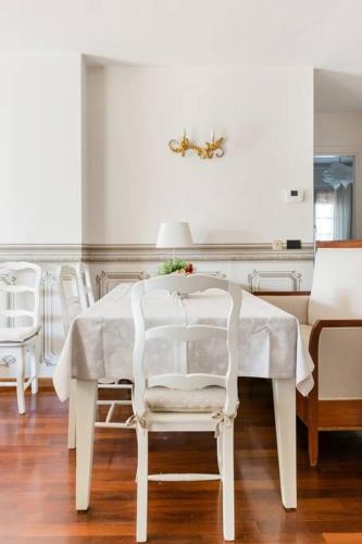 a white dining room table with white chairs and a table at Spacious, Air Conditioner, Few Minutes to the Castle in Malcesine