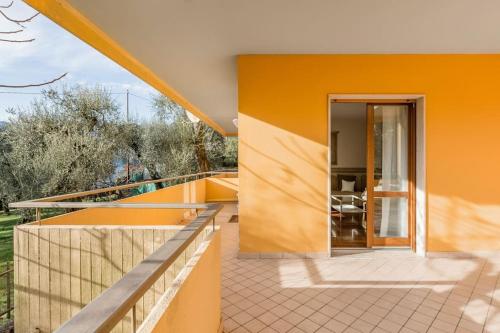 a house with an orange wall and a balcony at Spacious, Air Conditioner, Few Minutes to the Castle in Malcesine