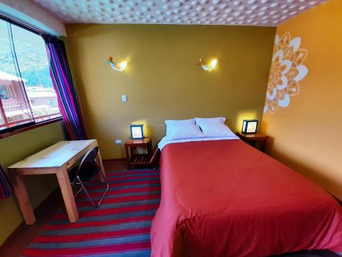 a room with a bed and a table and a window at Pisac Inca Guest House in Pisac