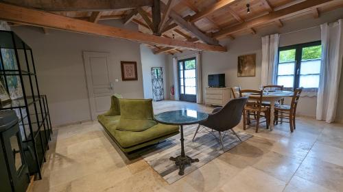 ein Wohnzimmer mit einem Tisch und Stühlen in der Unterkunft Domaine de Montboulard in Soyaux