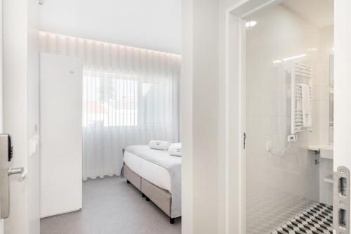 a white bathroom with a bed and a shower at Soho Porto in Porto