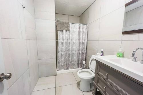 een witte badkamer met een toilet en een wastafel bij Spacious 3BR 3 Bath close to Niagara Falls in Niagara Falls