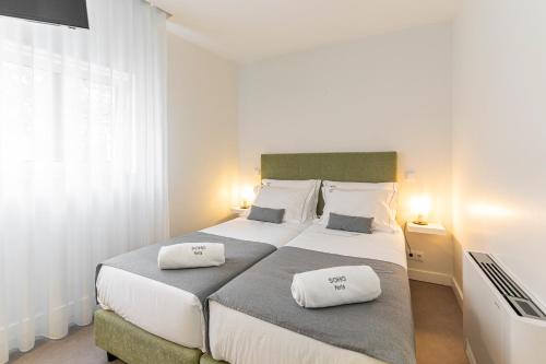 a bedroom with two beds with white pillows on them at Soho Porto in Porto