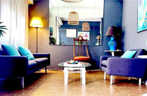 un soggiorno con 2 divani blu e un tavolo di HOTEL MORASHÁ a Mar del Plata