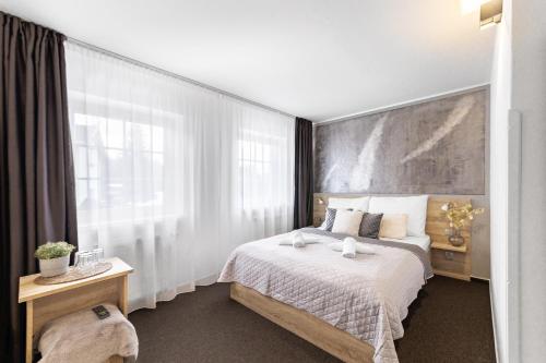a bedroom with a bed and a large window at Penzion Pepovka in Filipovice