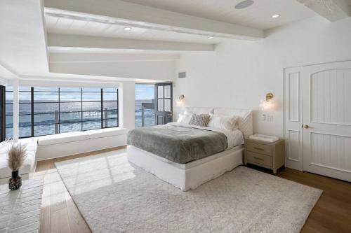 Dormitorio blanco con cama y ventana grande en ৎ୭ Victoria ৎ୭, en Malibú