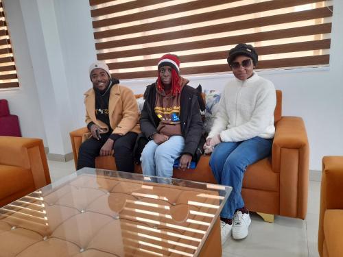 a group of three people sitting on a couch at Hotel Zoon Dabb Srinagar airport kashmir in Srinagar