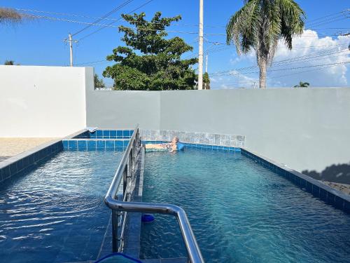 a person swimming in a swimming pool next to a wall at Casa Y in Tolú