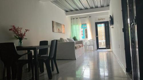 een woonkamer met een bank en een tafel met stoelen bij Casa Y in Tolú