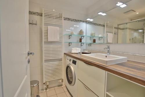 a bathroom with a sink and a washing machine at Stranddomizil Stranddomizil Appartement 13 in Haffkrug