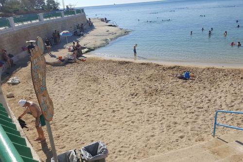 a group of people on a beach with a surfboard at Ramla Boutique Home in Marsaskala