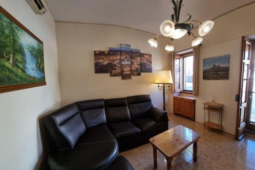 a living room with a black leather couch and a table at Ramla Boutique Home in Marsaskala