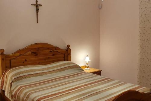 a bed in a bedroom with a cross on the wall at Ramla Boutique Home in Marsaskala