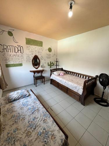 a bedroom with a bed and two rugs at Casa Jambo Hostel Para Mulheres in Guarujá