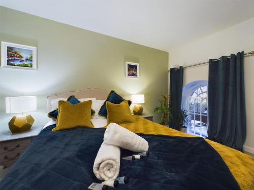 a bedroom with two beds with blue and yellow pillows at Modern Duplex Central Free Parking Wi-Fi in Cheltenham