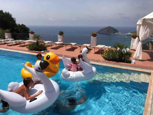 a group of people riding on inflatables in a swimming pool at Il Fico “Villa Nunzia” in Ischia