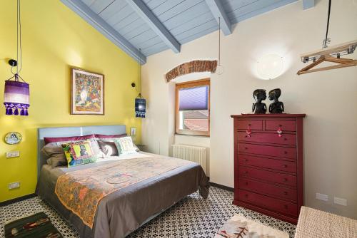 - une chambre avec un lit et une commode rouge dans l'établissement Rosso Malpelo, à La Spezia