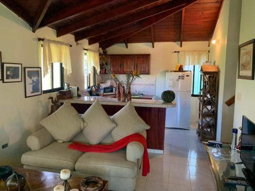 a living room with a couch and a kitchen at Villa Fe Esperanza - Vistas al Valle de Constanza in Constanza