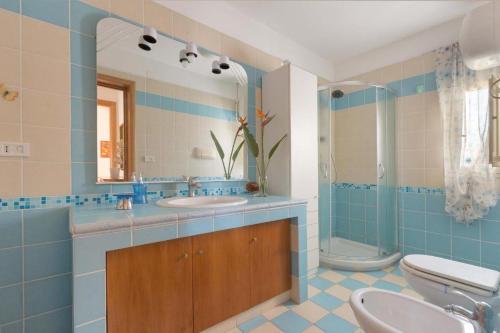 uma casa de banho com um lavatório, um WC e um espelho. em Villetta Ginetta em Torre Ovo