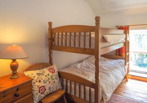 una camera con 2 letti a castello e una lampada di Pontfair - Charming Cottage 10 mins walk from beach a Llangrannog