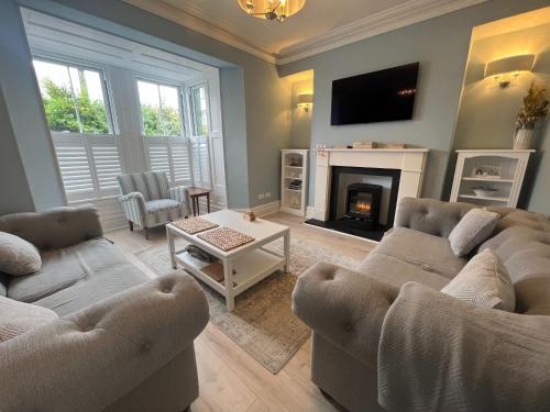 a living room with two couches and a fireplace at Polruan - stunning central NQ house - dog friendly in New Quay