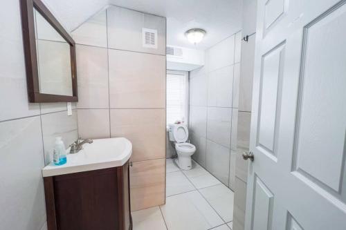 a white bathroom with a sink and a toilet at Relaxing 3BR 3 Bath close to the falls in Niagara Falls