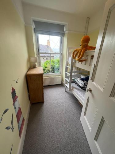 a small room with a bunk bed and a window at Polruan - stunning central NQ house - dog friendly in New Quay