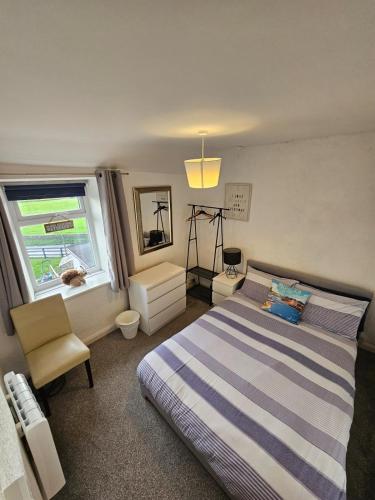 LlanenganにあるAbersoch Cottage llanenganのベッドルーム1室(ベッド1台、椅子、窓付)