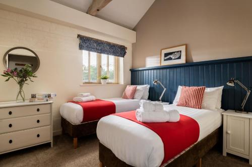 2 camas en una habitación con rojo y blanco en Wagtail, en Fakenham